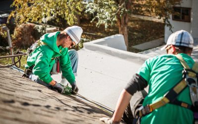 Solar panel installation crew members on roof of house